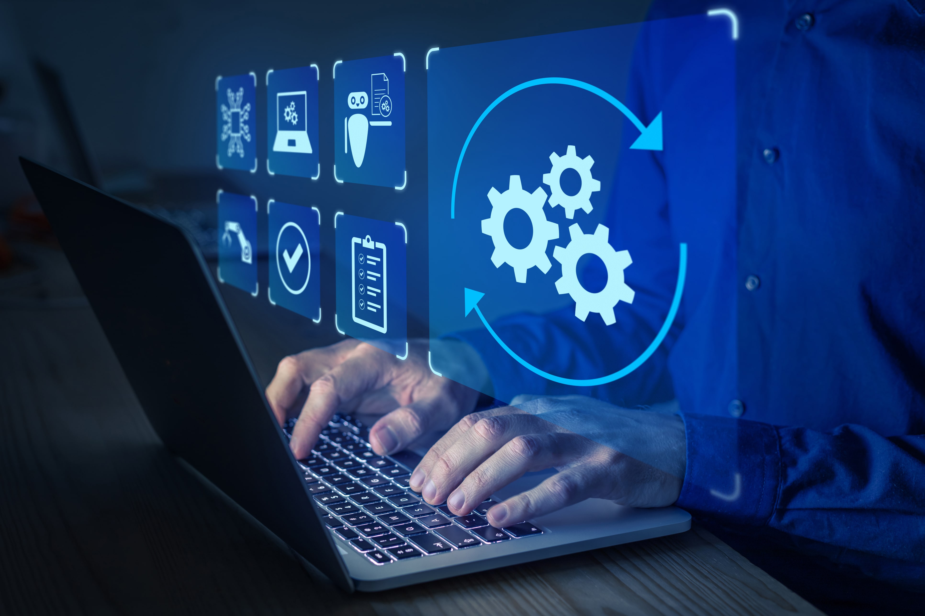 A businessman typing on his laptop with holograms of gears floating above his hands as he successfully overcomes challenges within his automated testing